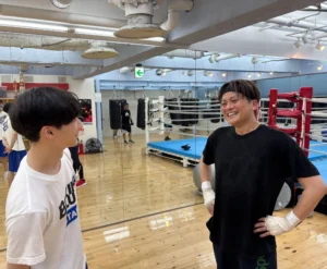 練習後にボクシングについて話すトレーナーと会員